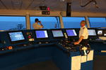 Foto, Bild: Kapitn auf der Schiffsbrcke abends mit der Hand am Maschinentelegraf (Fahrstufenregler)