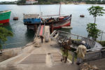 Foto, Bild: aus einer arabischen Dau im altem Hafen von Mombasa wird Trockenfisch entladen