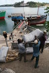 Foto, Bild: aus einer arabischen Dhau im altem Hafen von Mombasa wird Trockenfisch entladen