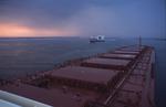 Foto, Bild: auf einem Massengutfrachter (Bulker, Bulk Carrier) mit neun Luken im Morgenlicht auf der Unterelbe