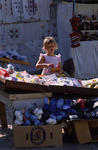 Foto, Bild: Mädchen in Sommerkleid feilscht auf dem Flohmarkt